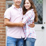 Portrait Of Loving Couple Standing Outside Home